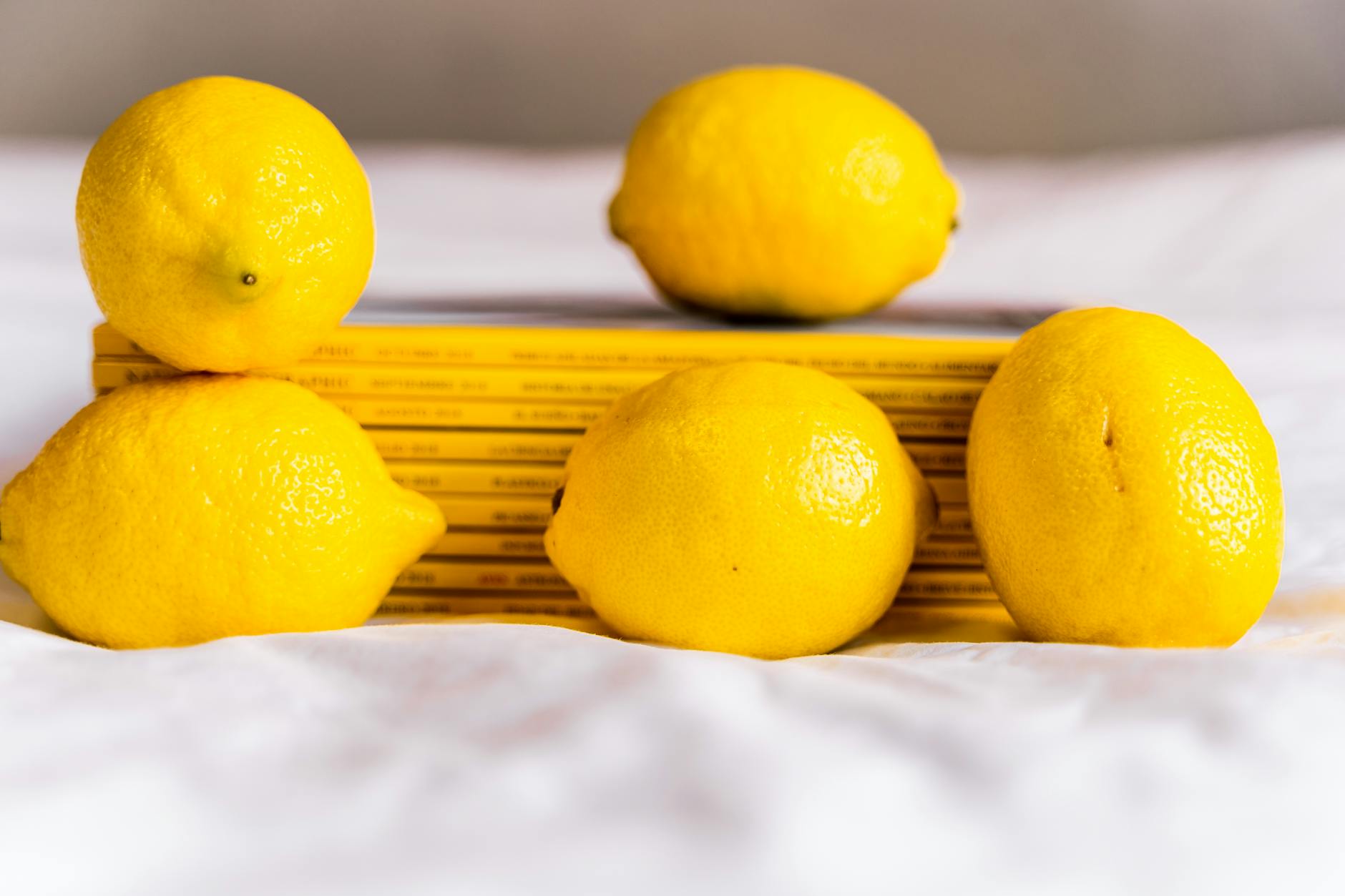 A blue vibrator surrounded by flowers and citrus slices on a bright yellow background